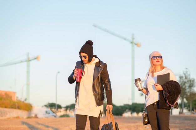 Couple with thermoses on street