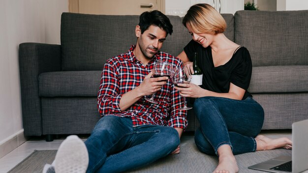 Foto gratuita coppia con vino al computer portatile