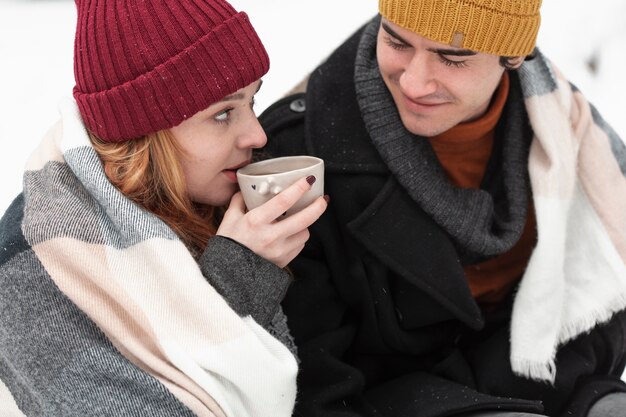 Пара с зимней одеждой пьет чай