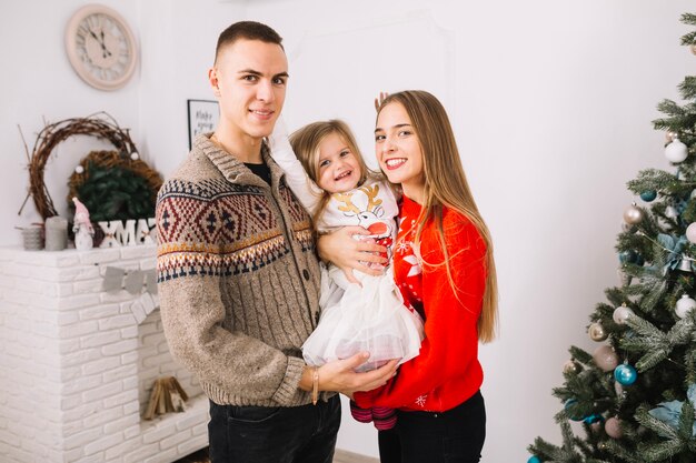 Couple with young daughter celebrating christmas at home