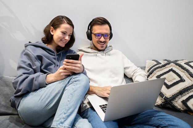 Couple working from home together on the sofa