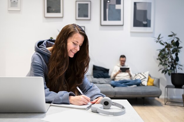 Couple working from home together on the sofa