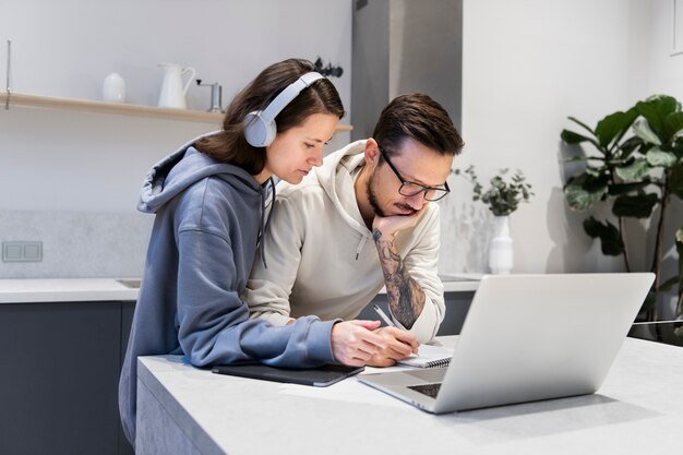 Couple working together from home kitchen