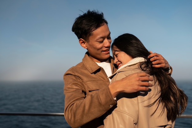 Foto gratuita coppie che si abbracciano vicino al mare