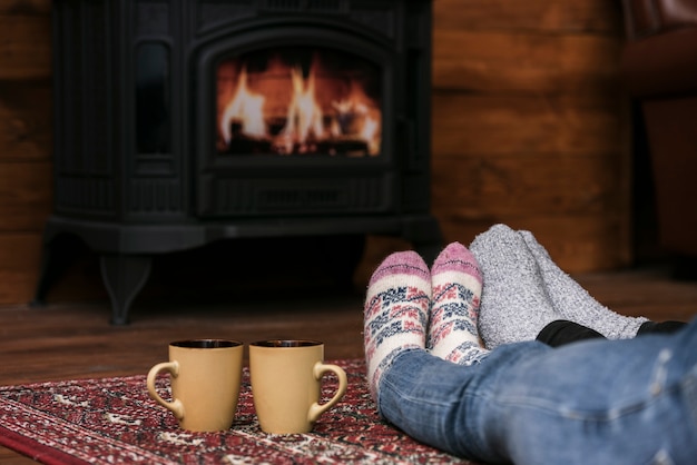 Couples warming feet next to fireplace