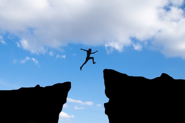 Бесплатное фото Мужественный человек прыгает через зазор между холмом, идея концепции бизнеса