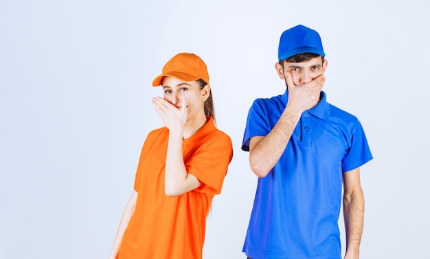 Free photo courier boy and girl in blue and yellow uniforms feel tired and sleepy.