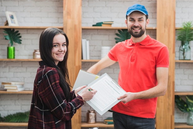 Free photo courier and customer with clipboard looking at camera