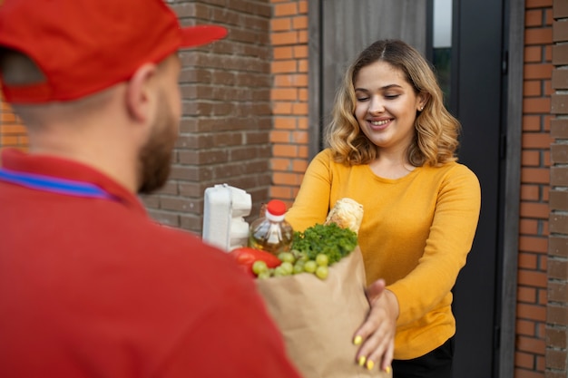 Free photo courier delivering groceries home