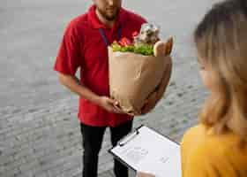 Free photo courier delivering groceries home