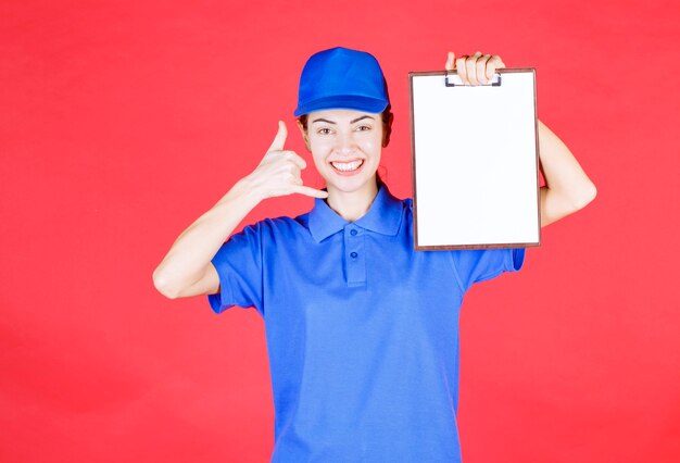 Courier girl in blue uniform holding a tasklist and asking for a call. 