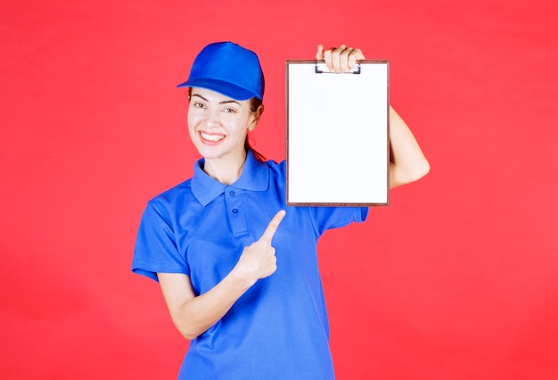 Free photo courier girl in blue uniform holding a tasklist.