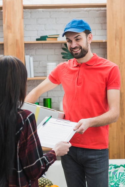 Free photo courier giving woman clipboard