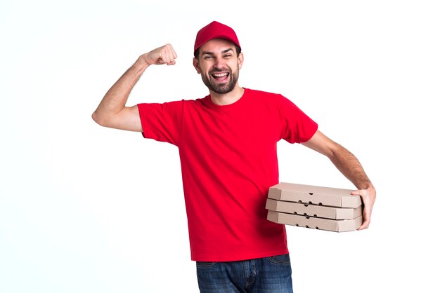 Courier man holding pile of pizza boxes and showing muscles