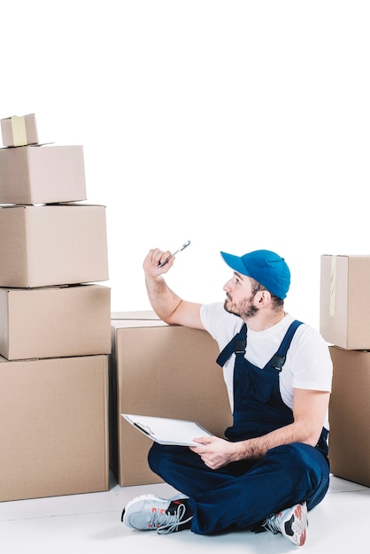 Courier with clipboard looking at parcels