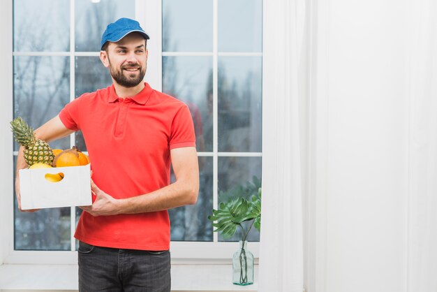 Courier with fruits looking away