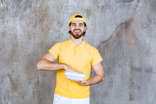 Courier in yellow uniform delivering a plastic takeaway box