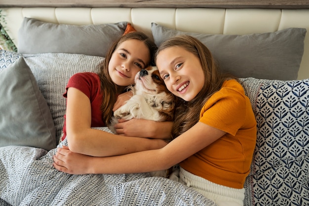 Cousins spending time together at home with pet dog