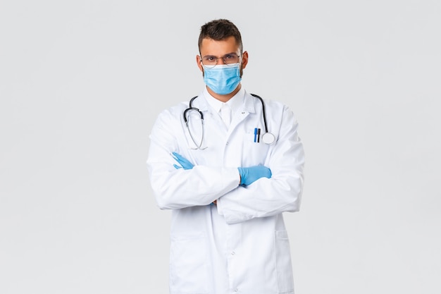코비드-19, 의료 종사자, 전염병 및 예방 바이러스 개념. 보호용 개인 장비, 의료 마스크, 장갑을 끼고 코로나바이러스 환자와 함께 일하는 진지한 의사.