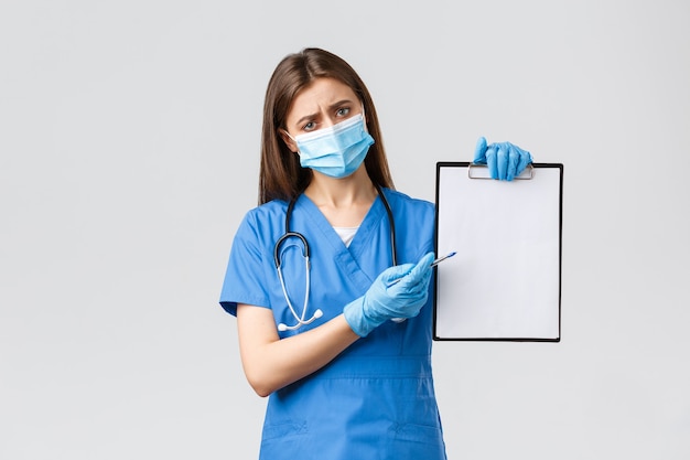 Covid-19, 바이러스, 의료 종사자 및 검역 개념을 예방합니다. 파란색 스크럽, 의료용 마스크를 쓴 피곤한 여성 간호사 또는 의사, 코로나바이러스 동안 마스크와 장갑 사용의 중요성을 설명합니다
