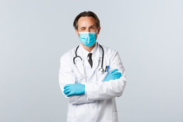 Covid-19、ウイルス、医療従事者、予防接種の概念を防ぎます。医療用マスクと手袋を着用したフレンドリーな専門医が、患者のリラックスを促します。