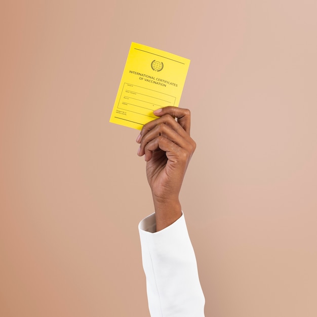 Free photo covid-19 vaccine certificate mockup psd held by a businessman’s hand