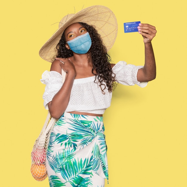 Foto gratuita covid 19, donna in maschera medica in possesso di una carta di credito