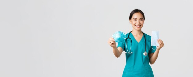 Covid coronavirus disease healthcare workers concept cheerful smiling asian female doctor in scrubs ...