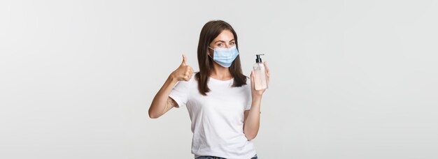 Бесплатное фото Ковид концепция здоровья и социального дистанцирования портрет довольной улыбающейся девушки в медицинской маске