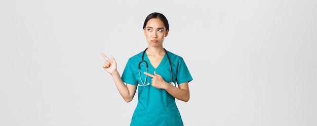 Концепция пандемии работников здравоохранения Covid разочаровала мрачную надутую азиатскую медсестру в скрабах ...