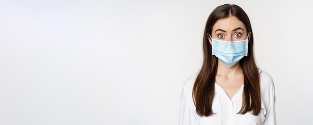 Free photo covid and pandemic concept young office woman wearing medical mask during coronavirus social distanc