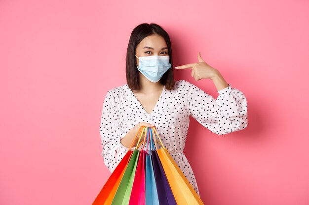 코비드 팬데믹과 라이프스타일 개념 쇼핑백을 들고 웃고 있는 귀여운 아시아 여성