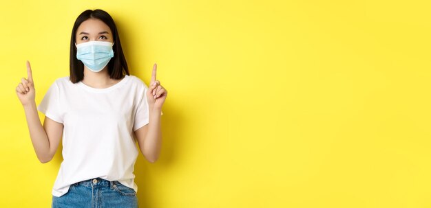 Covid pandemic and social distancing concept young asian woman in white tshirt and medical mask from