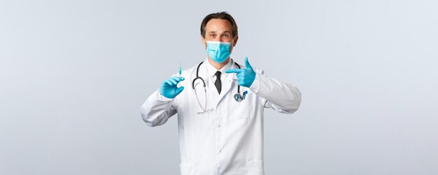Медицинские работники, предотвращающие вирус Covid, и концепция вакцинации, улыбающийся врач в медицинской маске и ...