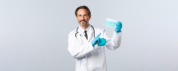 白衣を着た男性医師の笑顔のウイルス医療従事者と予防接種の概念を防ぐCovid