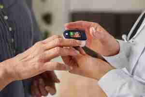 Free photo covid recovery center female doctor checking elder patient's oxygen level