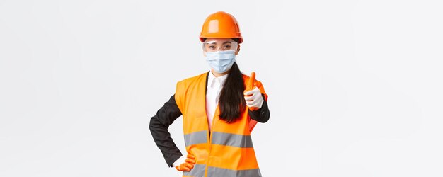 Covid safety protocol at enterpise construction and preventing virus concept confident asian female
