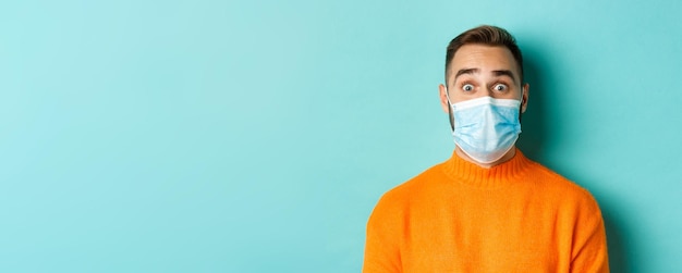 Free photo covid social distancing and quarantine concept closeup of young man in face mask staring at camera w