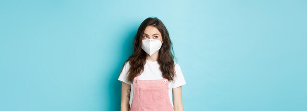 Free photo covid vaccination and quarantine concept young woman in medical mask wearing respirator and looking