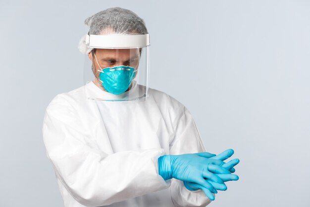 Covid virus healthcare workers and vaccination concept doctor in personal protective equipment put o...