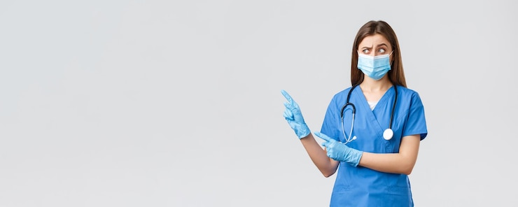 Free Photo covid19 preventing virus health healthcare workers concept skeptical and suspicious female nurse in blue scrubs medical mask and gloves look doubtful and pointing upper left corner