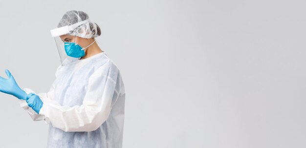 Covid19 preventing virus health healthcare workers and quarantine concept Young doctor in personal protective equipment nurse put on rubber gloves to work with coronavirus sick patient