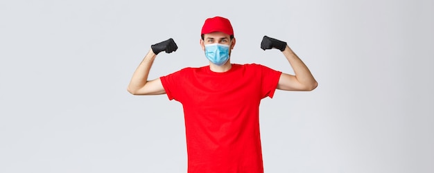 Covid19 selfquarantine online shopping concept Strong delivery guy flexing biceps showing strength carry and transfer heavy large parcels to clients express delivery to customer home