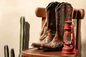 Free photo cowboy inspiration with boots and lamp on chair