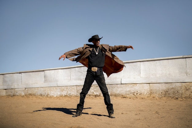 Foto gratuita siluetta del cowboy contro la luce calda