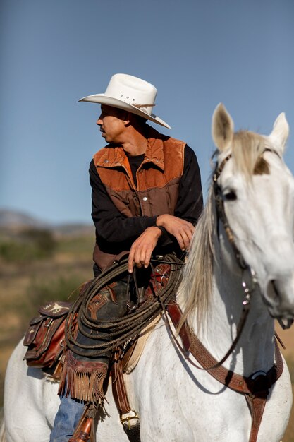 Cowboy silhouette with horse against warm light