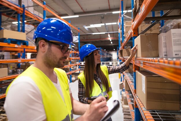 Coworkers checking inventory in large warehouse storage department