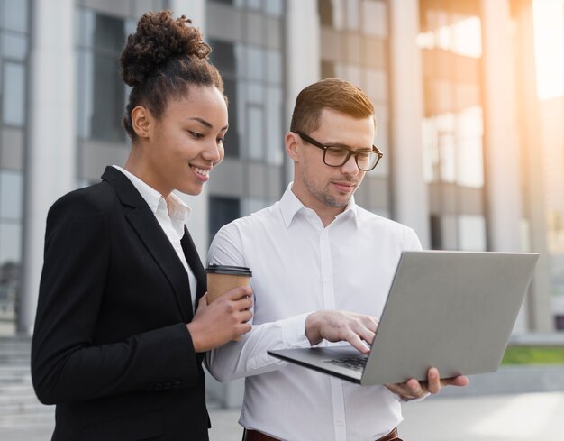 Coworkers looking at laptop medium shot