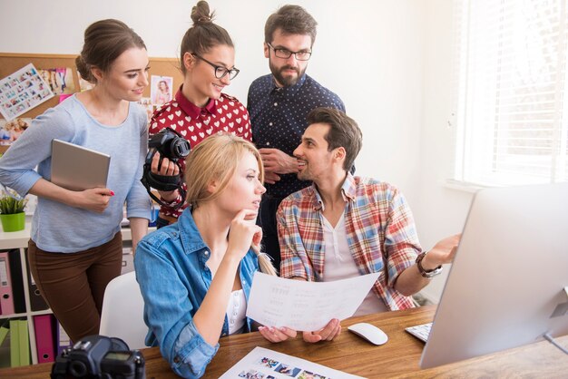 Coworkers at office with photo cameras and a computer