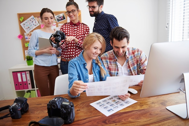 Coworkers at office with photo cameras and a computer